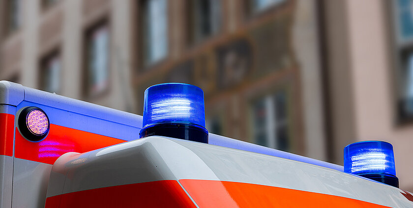 A german ambulance car with flashing blue lights in an urban area