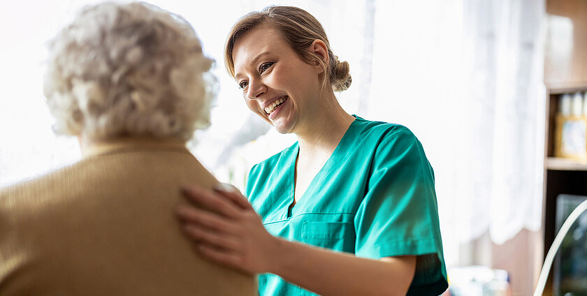 Friendly nurse supporting an elderly lady