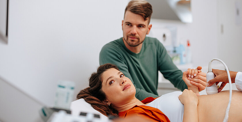 Pregnant woman watching ultrasound monitor.