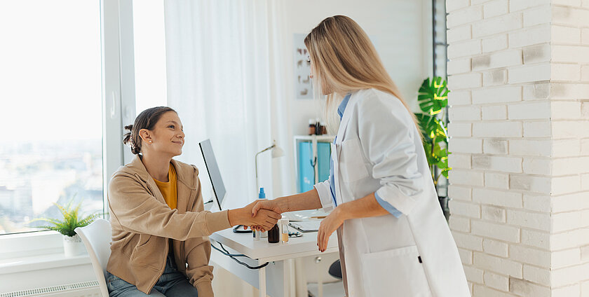 Teenage patient arriving at appointment with doctor, shaking hands with female pediatrician, physician. Teen girl have consultation, first visit with gynecologist. Concept of preventive health care for adolescents.