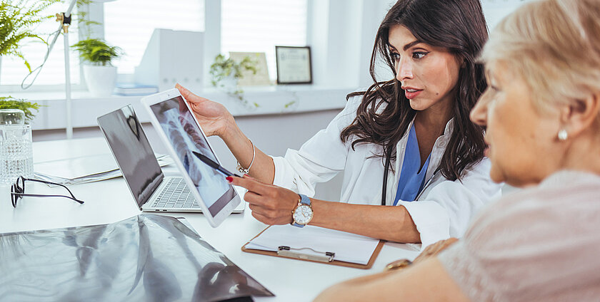 The doctor is analyzing and clarifying images of the patient's lung X-rays.