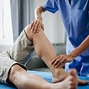 Close up of Physiotherapist working with patient on the bed