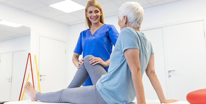 physiotherapist massaging and kneading a patient's leg provides medical care for sprained ligaments. Concept of rehabilitation and recovery after physical leg injuries.